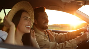 Happy couple enjoying trip together by car